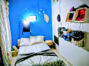 een slaapkamer met een blauwe muur met een bed erin bij há uma bela casa in Ubatuba