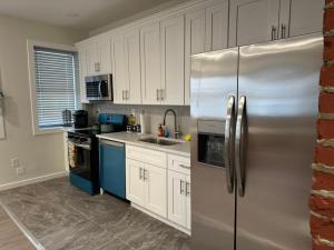 a kitchen with white cabinets and a stainless steel refrigerator at Hudson Valley Top Getaway with a River View in Newburgh