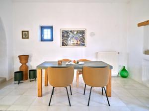 een eetkamer met een tafel en stoelen bij Leticia Villa with pool with amazing sea views, Paros in Márpissa