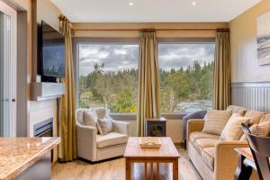 uma sala de estar com um sofá e uma janela grande em Oceanside GetAway at Pacific Shores em Nanoose Bay