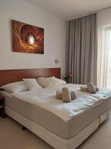 a large white bed in a bedroom with a window at Apartmán Lomnica - Tatragolf C 401 in Veľká Lomnica