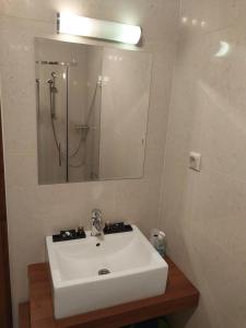 a bathroom with a white sink and a mirror at Apartmán Lomnica - Tatragolf C 401 in Veľká Lomnica
