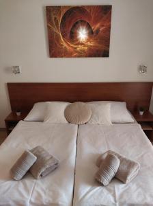 a large white bed with two pillows on it at Apartmán Lomnica - Tatragolf C 401 in Veľká Lomnica