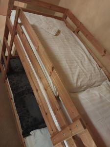 a wooden bunk bed with white sheets on it at Apartmán Lomnica - Tatragolf C 401 in Veľká Lomnica +40 photos
