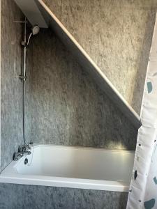 a bath tub in a bathroom with a shower at Coastal Nest in Margate +10 photos