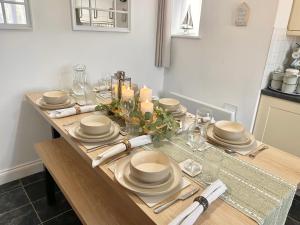 a dining room table with plates and candles on it at The Nest at Wynncroft in Torquay