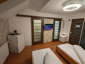 a living room with a bed and a refrigerator at Sleep&Go Airport Transit Rooms Cluj-Napoca in Cluj-Napoca