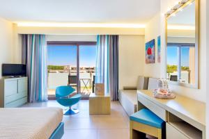 プリノスにあるALEA Hotel & Suitesのベッドとデスクが備わるホテルルームです。