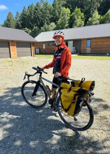 un hombre está de pie junto a una bicicleta en Athol Country Bed & Breakfast, en Athol