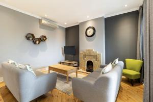 een woonkamer met twee stoelen en een open haard bij Central Green Point Apartment in Kaapstad