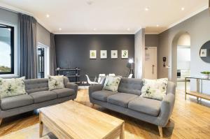 een woonkamer met twee banken en een salontafel bij Central Green Point Apartment in Kaapstad