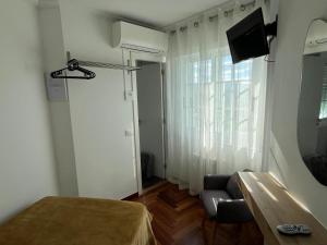 a room with a couch and a television and a window at PR Una Estrella Dorada in O Pedrouzo +61 photos
