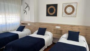 due letti in una stanza con blu e bianco di PR Una Estrella Dorada a O Pedrouzo
