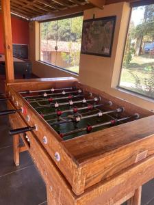 uma grande mesa de bilhar de madeira em uma sala com em Pousada São Sebastião em São Sebastião do Rio Verde