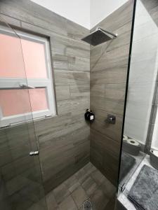 un bagno con doccia con porta in vetro di Increíble departamento en Juriquilla Qro a Juriquilla