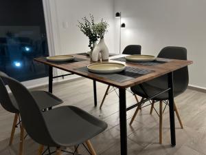 un tavolo da pranzo con sedie e un vaso sopra di Increíble departamento en Juriquilla Qro a Juriquilla Altre 11 foto