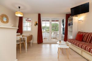 een woonkamer met een bank en een eetkamer bij Atlantic Selection - Domaine de Bordaberry - Avec piscine et vue océan in Urrugne