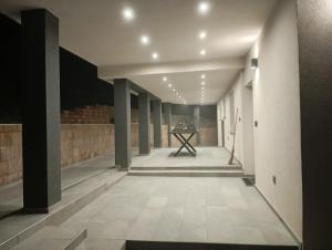 um corredor vazio com colunas e uma mesa em um prédio em Apartmaji Divji vrt em Lendava