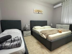 a bedroom with two beds and a window at S&E apartments in Tirana +5 photos