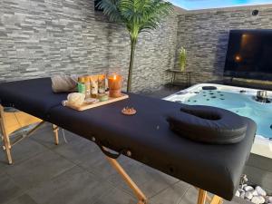 un lit avec un pneu dessus à côté d'un jacuzzi dans l'établissement Suite SPA PRIVÉE, à Portet-sur-Garonne