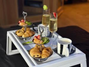 une table garnie d'assiettes de nourriture et de coupes de champagne dans l'établissement Suite SPA PRIVÉE, à Portet-sur-Garonne