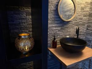 La salle de bains est pourvue d'un lavabo et d'un miroir. dans l'établissement Suite SPA PRIVÉE, à Portet-sur-Garonne