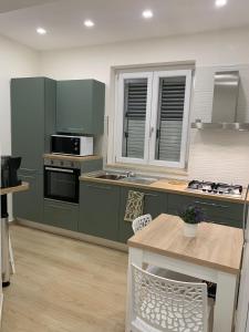 サン・ユーフェミア・ラメツィアにあるb&b NEAR AIRPORT LAMEZIAの緑のキャビネットとコンロのあるキッチン トップオーブン