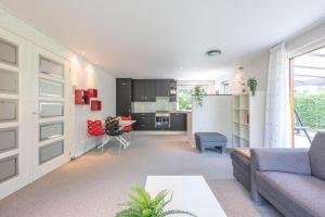 a living room with a couch and a kitchen at Jonkerstee 21 - Ouddorp in Ouddorp +8 photos