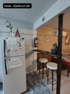 eine Küche mit einem Kühlschrank und 2 Barhockern in der Unterkunft Departamento Interno Cande in Salta