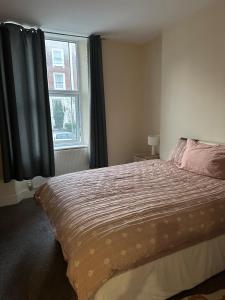 a bedroom with a large bed and a window at The Albert, Montpellier in Bristol