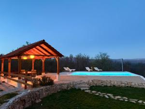 a swimming pool with a gazebo and a swimming pool at Villa Billubium - Dalmatian Stone House with Private Heated Pool in Zovko