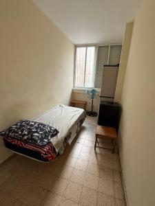 a bedroom with a bed and a table and a window at דירת ציון in Petaẖ Tiqwa +2 photos