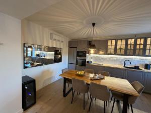 a kitchen with a wooden table and some chairs at Villa Billubium - Dalmatian Stone House with Private Heated Pool in Zovko