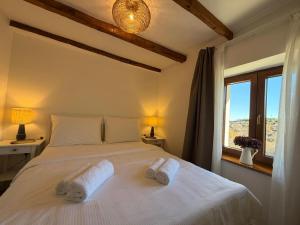 a bedroom with a bed with two towels on it at Villa Billubium - Dalmatian Stone House with Private Heated Pool in Zovko +26 photos