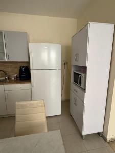 a kitchen with a white refrigerator and a microwave at דירת ציון in Petaẖ Tiqwa