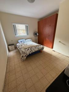 a bedroom with a bed and a window at דירת ציון in Petaẖ Tiqwa