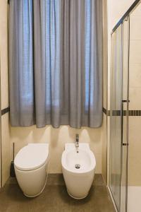 a bathroom with a toilet and a sink at Portico 33 in Treviso +16 photos