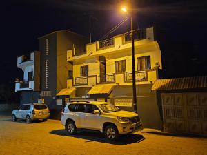 two vehicles parked in front of a building at night at Residence Ganou Mboro in Mboro