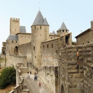 un gran castillo con gente caminando por una calle en Aude Cité-City, en Carcassonne