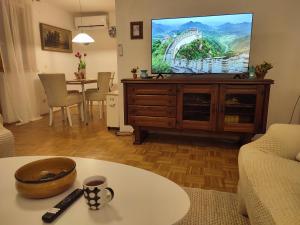 a living room with a tv and a table at Garden House in Sarajevo