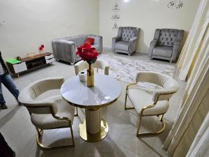 a living room with chairs and a table with a vase of flowers at Residence Ganou Mboro in Mboro