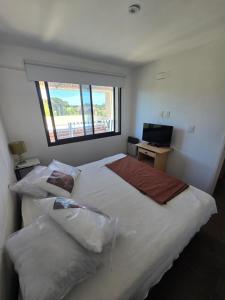 een slaapkamer met een groot bed en een raam bij Complejo la argentina in Ostende