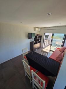 een woonkamer met een tafel, stoelen en een televisie bij Complejo la argentina in Ostende