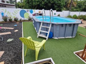 a backyard with a pool with a ladder and a chair at Villa Atlantis 3 chambres in Port-Louis