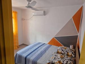 a bedroom with a bed with a blue and white comforter at Villa Atlantis 3 chambres in Port-Louis
