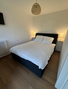 a bedroom with a large bed with white sheets and pillows at Ferienwohnung Lüttje Mööv 2 an der Nordsee in Wangerland +13 photos