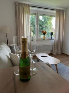 a bottle of wine sitting on a table with a wine glass at Ferienwohnung Lüttje Mööv 2 an der Nordsee in Wangerland