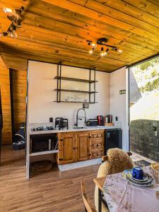eine Küche mit Holzdecken, einem Tisch und einer Theke in der Unterkunft Chales Caixa Daco in Porto Belo