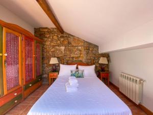 ein Schlafzimmer mit einem Bett und einer Steinwand in der Unterkunft Casa Chuchi in Ampuero