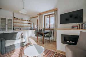 a living room with a couch and a fireplace at WHY NOT Apartamenty widokowe PANORAMA in Kościelisko +12 photos